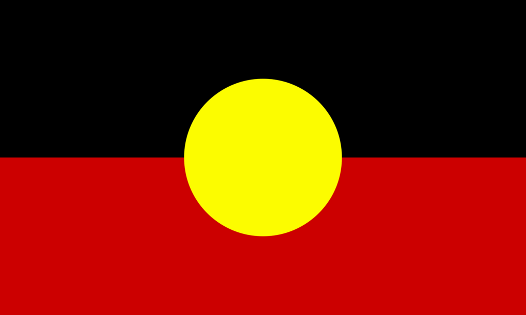 Aboriginal Flag with a black top half, red bottom half, and a yellow circle in the centre.